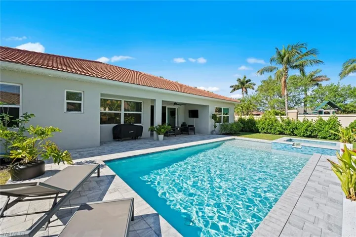View of swimming pool with a patio area and a pool with connected hot tub