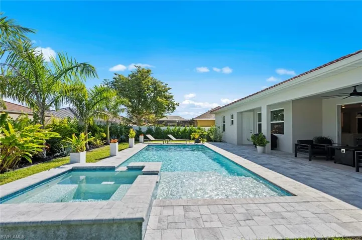 View of pool with a patio area, a pool with connected hot tub, and a fenced backyard