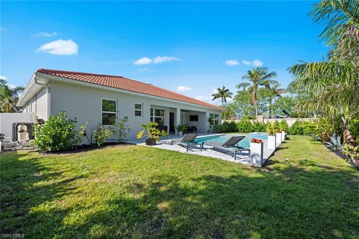 Back of property with a patio area, a tiled roof, and stucco siding