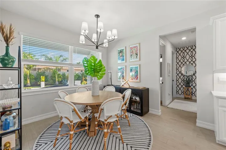 Dining space with light wood-style floors and a chandelier