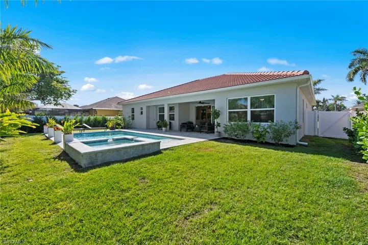 Back of house with a ceiling fan, a fenced backyard, a gate, a patio area, and a tile roof