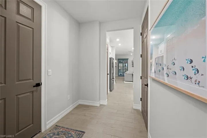 Corridor with baseboards and light wood-type flooring