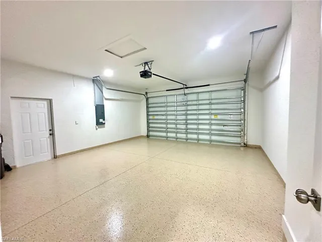 Garage featuring electric panel and a garage door opener