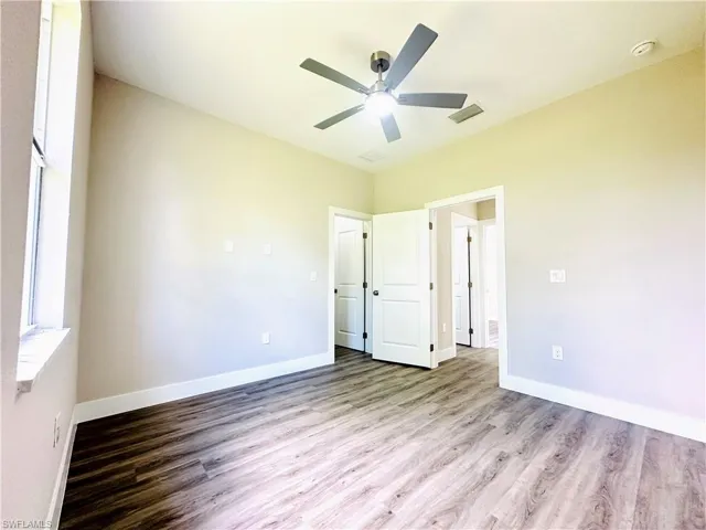 Unfurnished bedroom featuring wood finished floors and a ceiling fan