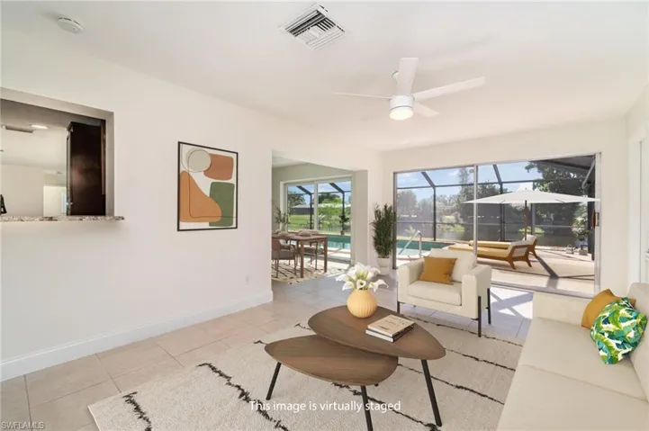 Living area with a sunroom, tile patterned flooring, and a ceiling fan
