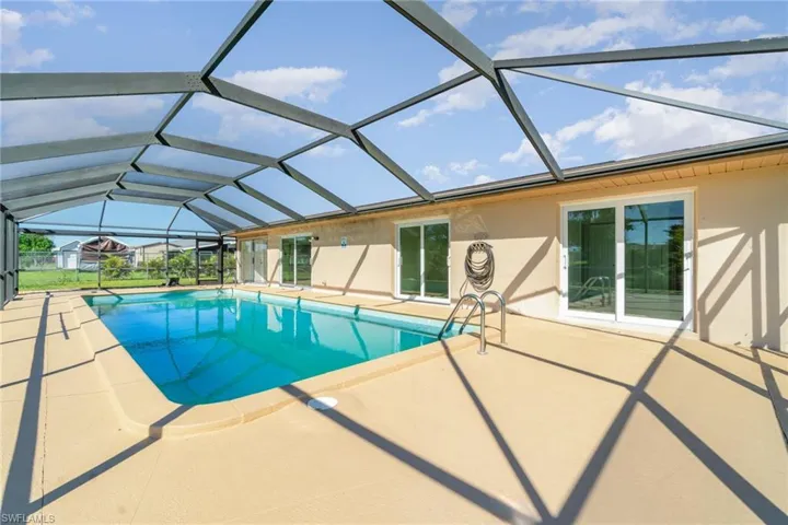 Outdoor pool with a sunroom, a patio, and glass enclosure