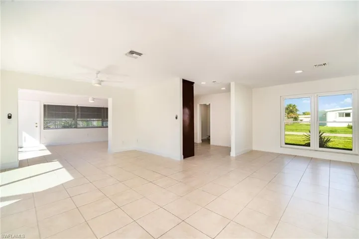 Empty room with light tile patterned flooring, a ceiling fan, and recessed lighting