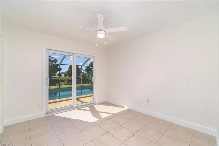 Spare room with a sunroom, a ceiling fan, and light tile patterned floors