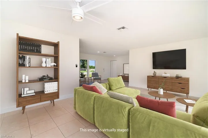 Living area with light tile patterned flooring and a ceiling fan