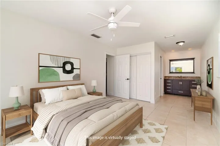 Bedroom with light tile patterned floors, a ceiling fan, and a closet