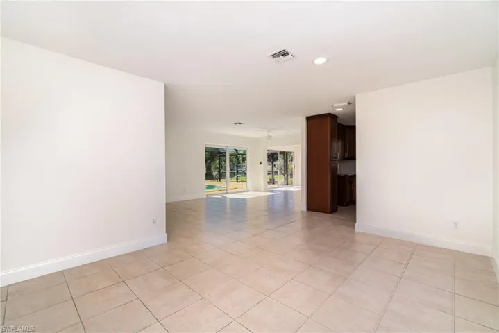 Empty room featuring light tile patterned floors and recessed lighting