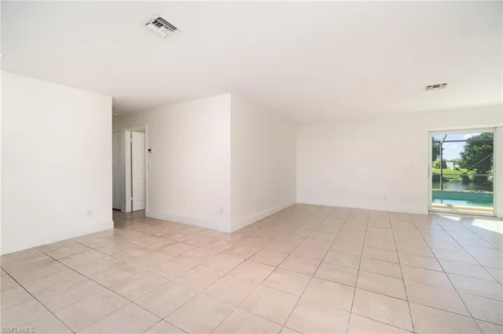 Empty room featuring light tile patterned floors and baseboards