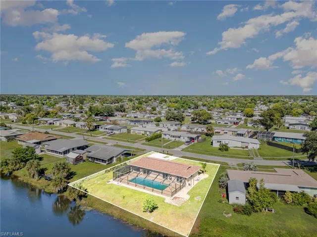 Aerial view of residential area featuring a large body of water and property boundaries highlighted