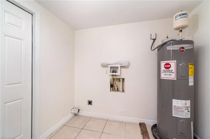 Washroom featuring electric water heater, light tile patterned floors, washer hookup, and electric dryer hookup