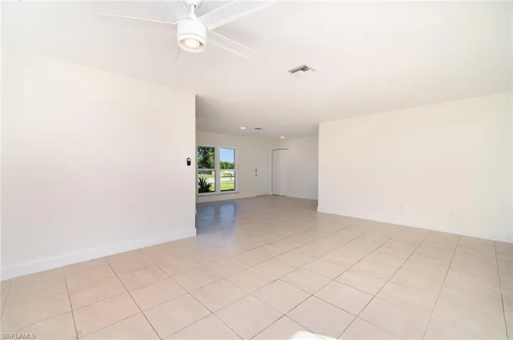 Unfurnished room featuring light tile patterned floors and ceiling fan