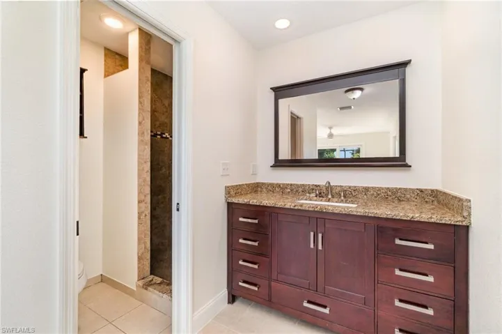 Full bath featuring vanity, light tile patterned flooring, a shower stall, and recessed lighting