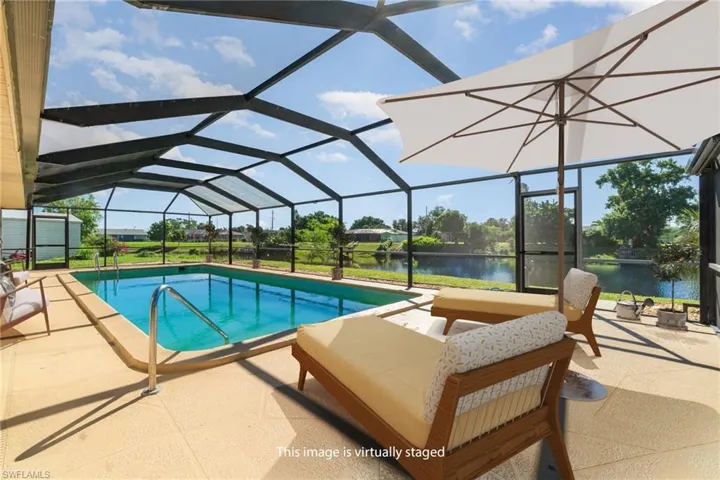 Swimming pool with a sunroom, a lanai, a patio, and a water view