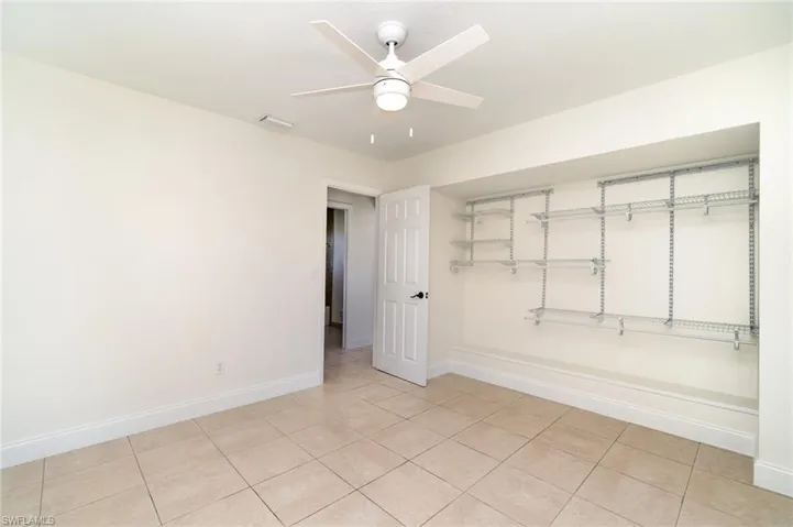 Unfurnished bedroom featuring ceiling fan and light tile patterned floors