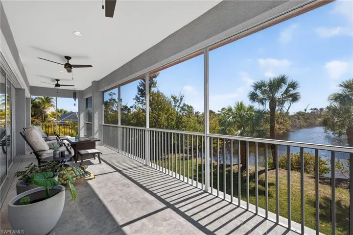 Sunroom featuring a ceiling fan, a water view, and a balcony