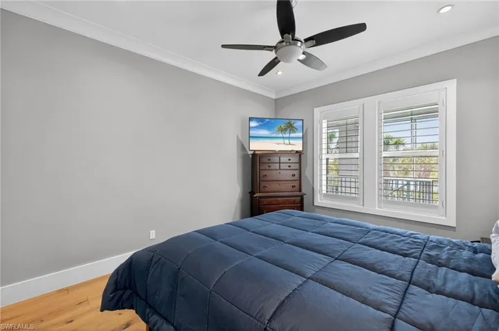 Bedroom featuring wood finished floors, ornamental molding, a ceiling fan, and recessed lighting