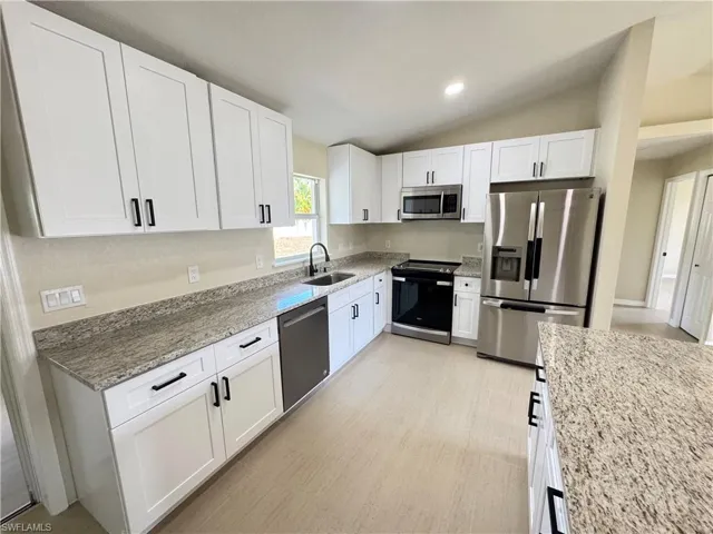 Kitchen featuring shaker-style cabinetry with black hardware, granite countertops, and stainless steel appliances
