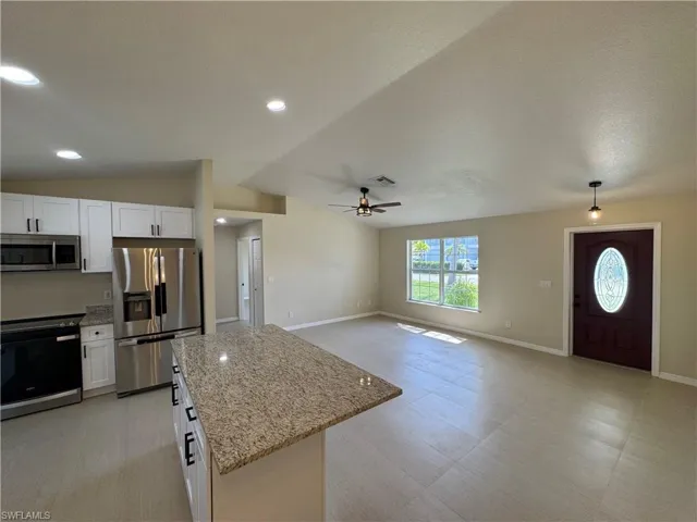 Open-concept living area featuring a vaulted ceiling and recessed lighting