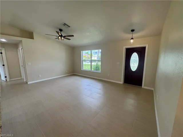 Spacious Great Room area featuring neutral-toned walls, large format tile flooring, and a contemporary ceiling fan