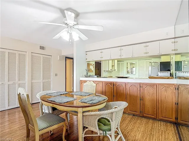 Dining space with a ceiling fan and light wood-style flooring