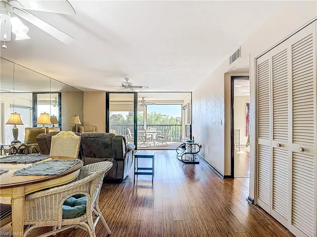 Living area featuring ceiling fan, wood finished floors, healthy amount of natural light, and expansive windows