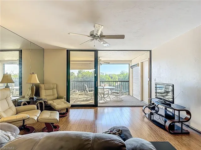 Living area featuring floor to ceiling windows, hardwood / wood-style flooring, and ceiling fan