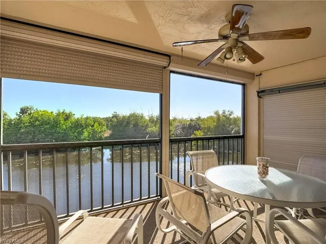 Sunroom / solarium with a water view and view of wooded area
