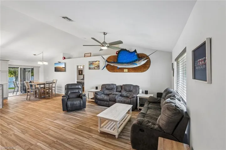 Spacious living area featuring vaulted ceilings and wood-finish flooring