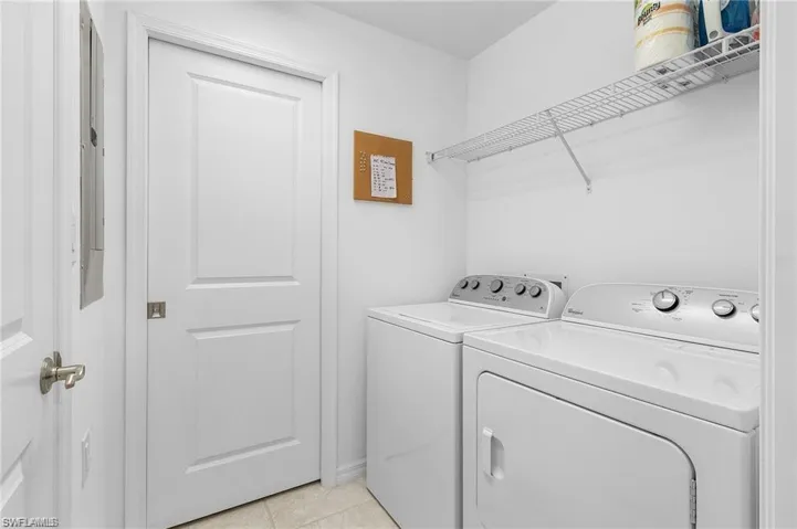 Laundry area featuring separate washer and dryer and light tile patterned flooring