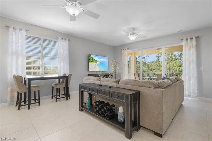 Living room with ceiling fan and light tile patterned floors