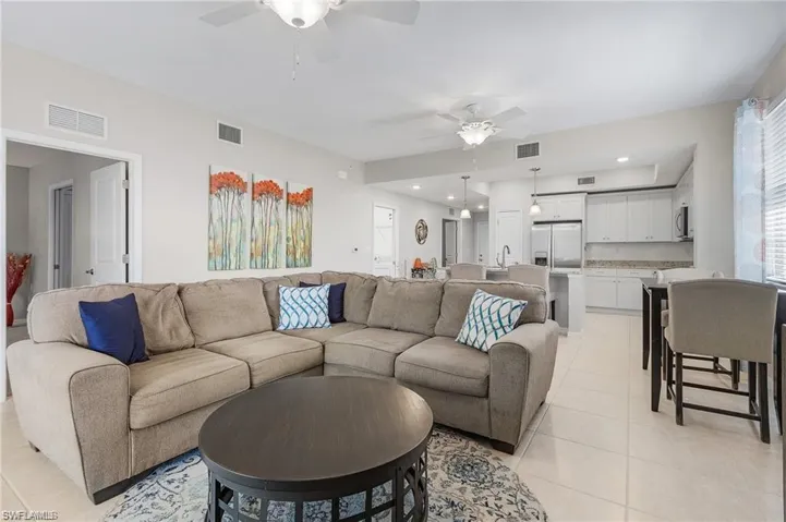 Living room featuring ceiling fan, light tile patterned floors, and sink