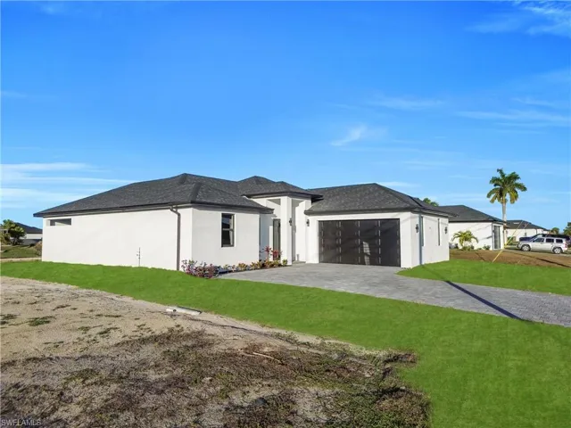 View of front of house with a front lawn, decorative driveway, stucco siding, a garage, and roof with shingles
