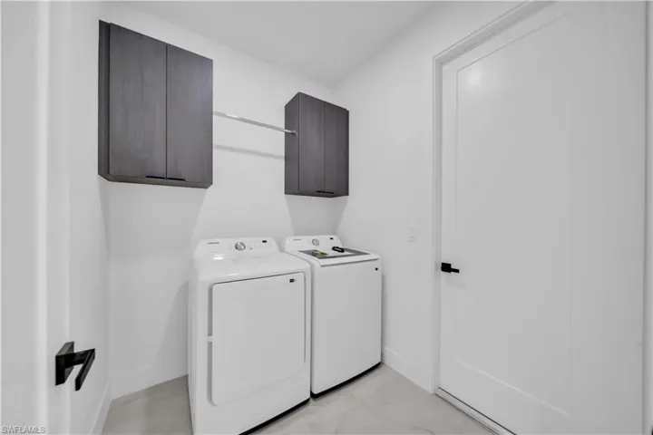 Laundry area featuring cabinet space and separate washer and dryer