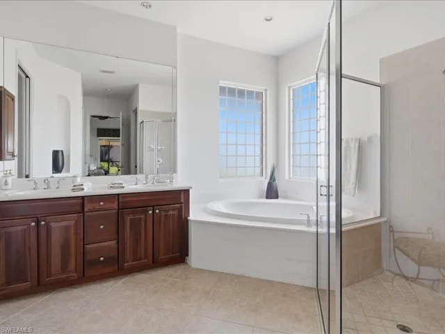 Spacious interior featuring a ceiling fan, white window shutters, and a sliding glass door leading to an outdoor screened patio