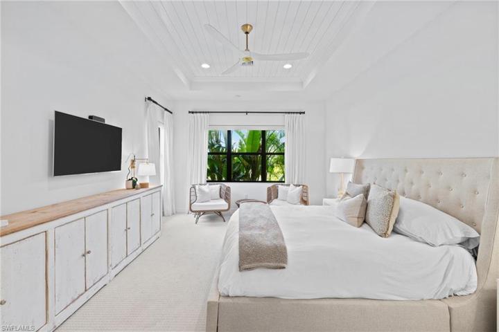 Spacious Primary Bedroom with room for seating and shiplap ceiling