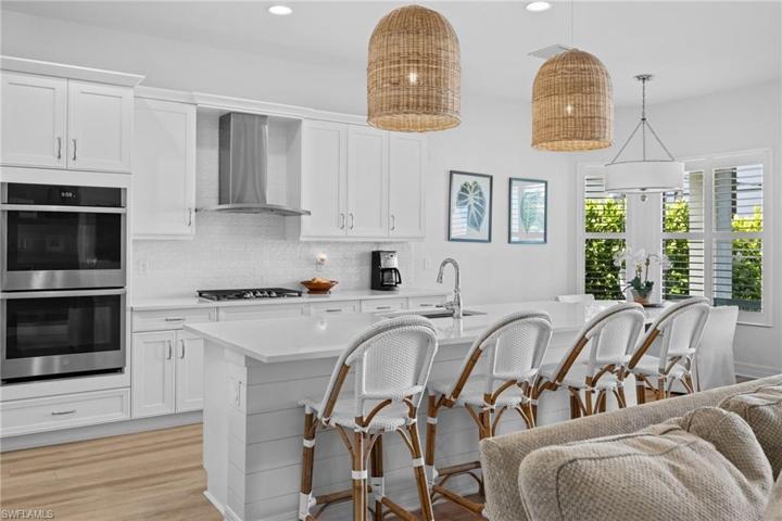 Gas Cooking and wall ovens along with a large Island with Quartz Counter and Shiplap finish