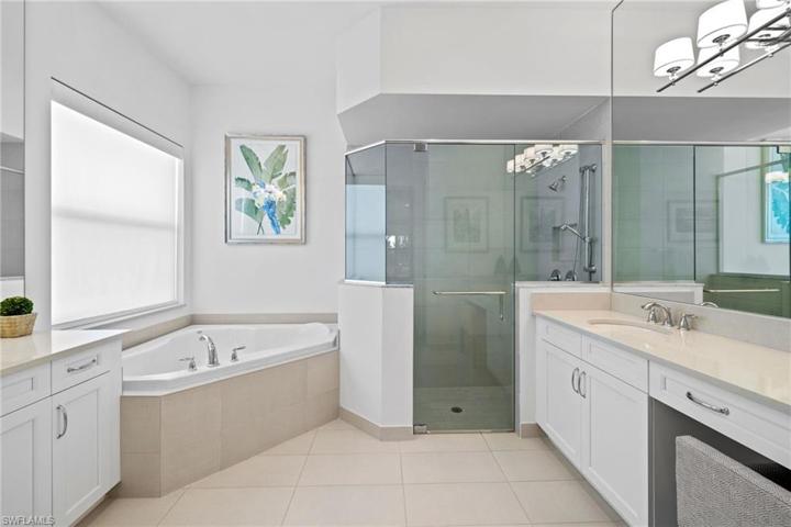 Two vanities and soaking tub, multi shower heads, quartz counter and lots of mirrors in the primary bath