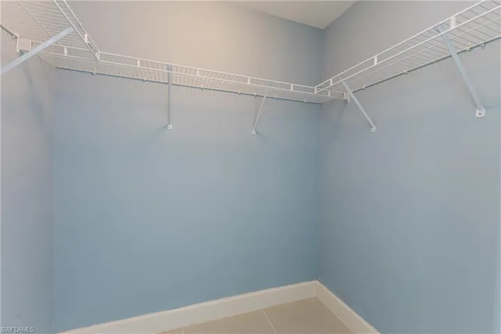 Walk in closet with light tile patterned flooring