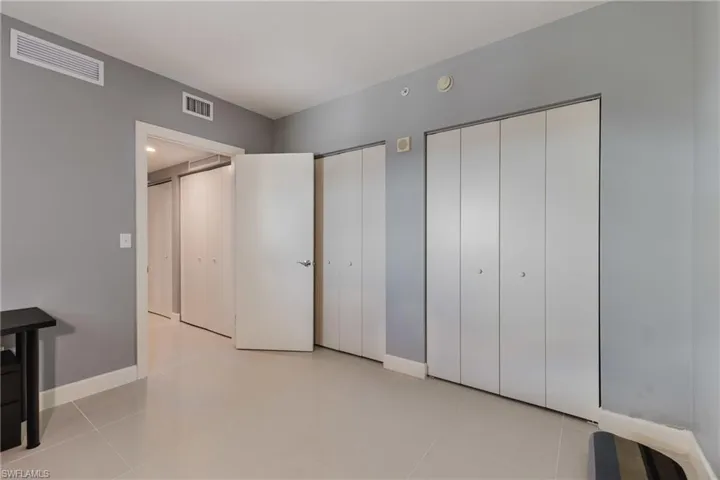 Unfurnished bedroom with multiple closets and light tile patterned floors
