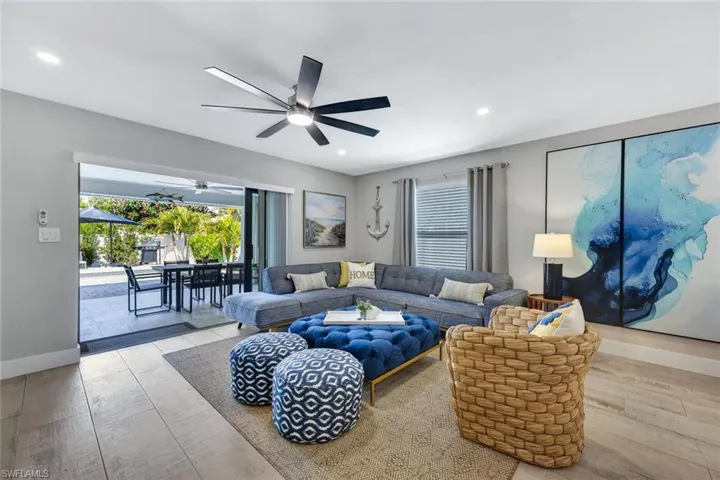 Living room featuring light wood finished floors, healthy amount of natural light, ceiling fan, and recessed lighting