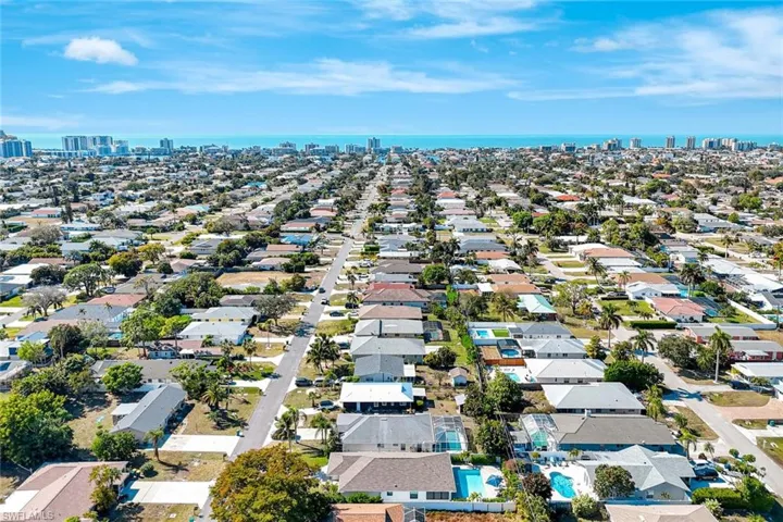 Aerial view of property and surrounding area with city skyline, a large body of water, and nearby suburban area