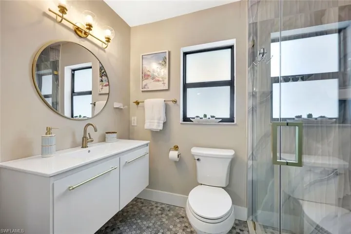 Full bathroom featuring vanity and a marble finish shower