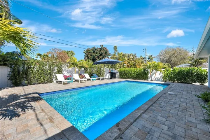 View of pool featuring patio surround, a fenced backyard, and area for grilling