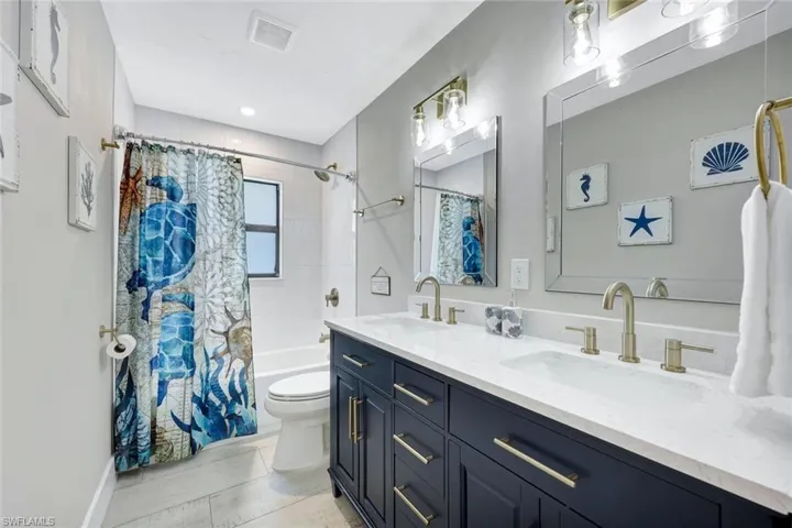 Bathroom with shower / bath combo and double vanity