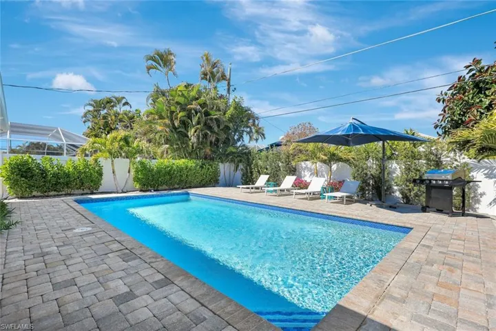 View of pool featuring patio surround, a fenced backyard, and area for grilling