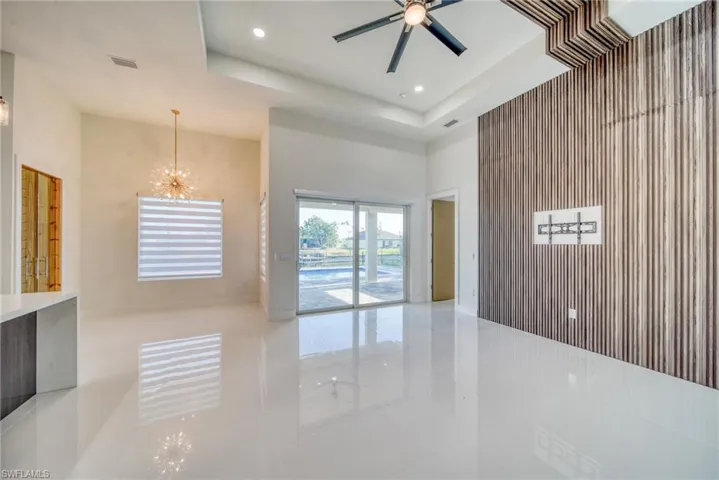Unfurnished room with a high ceiling, tile patterned floors, a chandelier, recessed lighting, and a ceiling fan